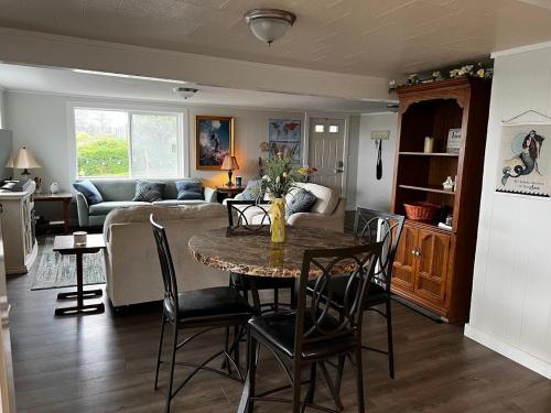 sala de estar con mesa, sillas y sofá en Idlewild Manor Vacation home, en Gold Beach