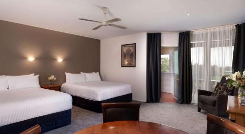 Habitación de hotel con 2 camas y mesa en Arawa Park Hotel, Independent Collection by EVT, en Rotorua
