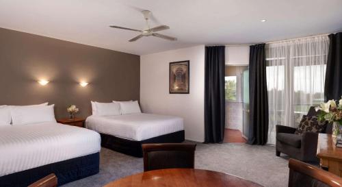 a hotel room with two beds and a table at Arawa Park Hotel, Independent Collection by EVT in Rotorua