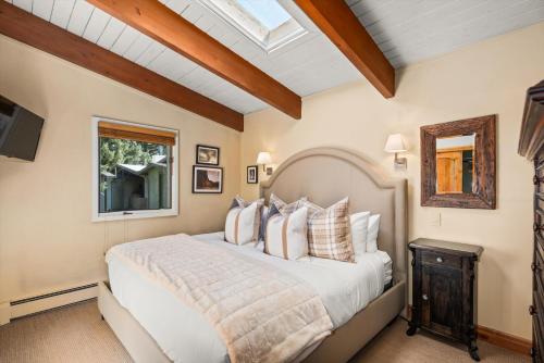 a bedroom with a large bed and a skylight at Little Nell Condominiums Unit 11, Top Floor Condo with Mountain Views, 3 Blocks to Gondola in Aspen