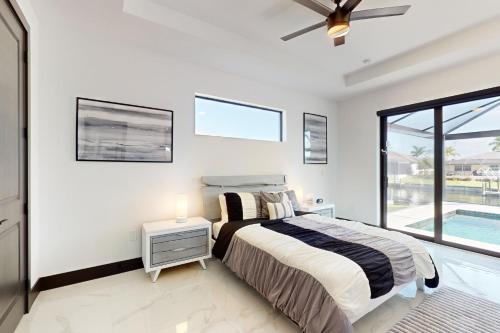 ein Schlafzimmer mit einem Bett und ein Fenster mit einem Pool in der Unterkunft Sunset Serenity in Cape Coral
