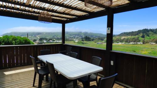 a table and chairs on a deck with a view at Casalmar Pupuya in Pupuya