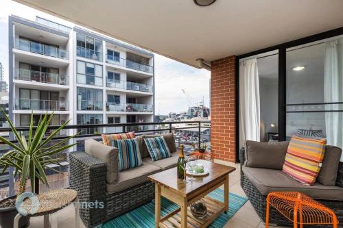 a balcony with a couch and a table on a building at 2 Bedroom 2 Bathroom Apt with Balcony and Parking in Sydney