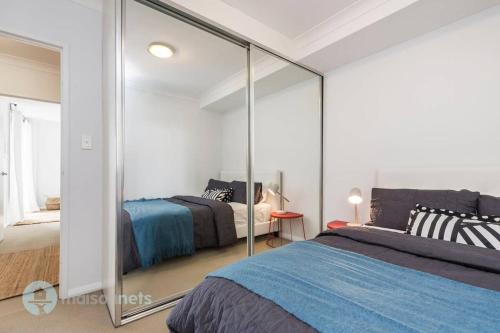 una camera con due letti e uno specchio di 2 Bedroom 2 Bathroom Apt with Balcony and Parking a Sydney