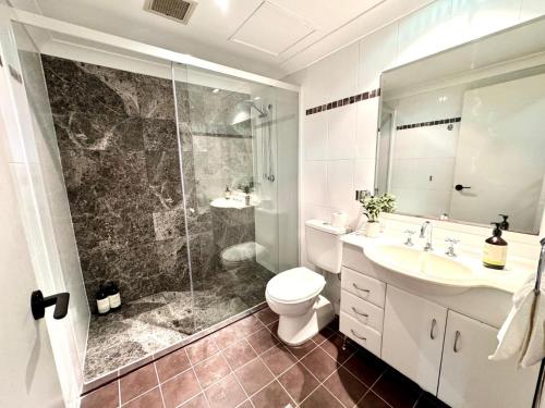 een badkamer met een douche, een toilet en een wastafel bij 2 Bedroom 2 Bathroom Apt with Balcony and Parking in Sydney