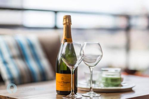 a bottle of champagne and two glasses on a table at 2 Bedroom 2 Bathroom Apt with Balcony and Parking in Sydney