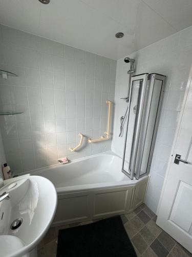 a bathroom with a shower and a tub and a sink at Four mile bridge by Trearddur bay in Valley
