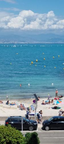 une plage avec des gens sur le sable et l'eau dans l'établissement appartement plage de la Salis, à Antibes
