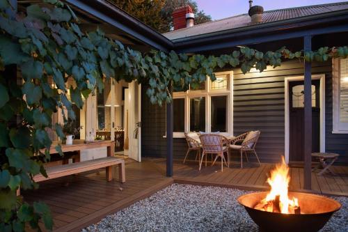 a deck with a fire pit and a table and chairs at The Elm Tree in Daylesford