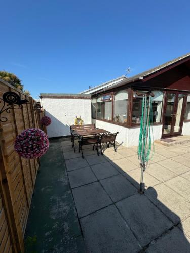 a patio with a picnic table and an umbrella at Four mile bridge by Trearddur bay in Valley