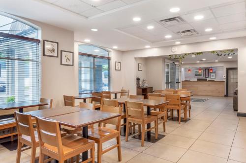 a dining room with wooden tables and chairs at Country Inn & Suites by Radisson, Newport News South, VA in Newport News