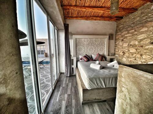 ein Schlafzimmer mit einem Bett und einer Steinmauer in der Unterkunft Villa Charfa Élégance Confort et Vues Panoramiques in Essaouira