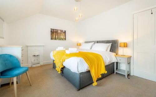 ein Schlafzimmer mit einem Bett mit einer gelben Decke darauf in der Unterkunft Loughrigg in Ambleside