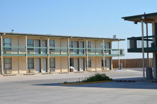 a large building with a parking lot in front of it at Plaza Inn in Big Spring