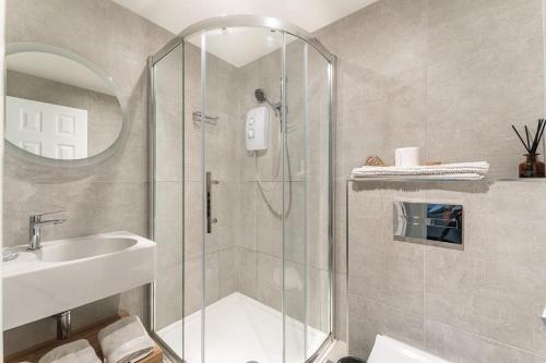 een badkamer met een douche en een wastafel bij Lowera Cottage in Windermere