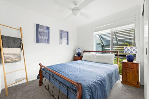 a bedroom with a bed and a ladder and a window at 4-53 Forsters Bay Road, Narooma - Blue Water Villas in Narooma