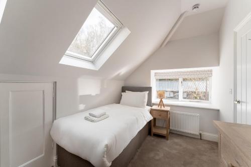 Un dormitorio con una cama blanca y una ventana. en Meadowsweet, en Ambleside