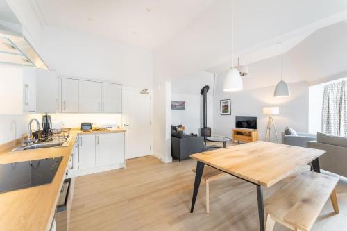 Una cocina y una sala de estar con una mesa de madera. en Meadowsweet, en Ambleside