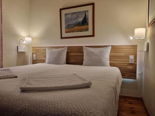 um quarto com uma cama grande e uma cabeceira em madeira em Margarida Guest House - Rooms em Almada