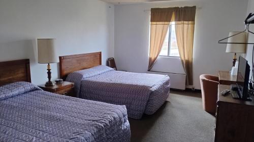 Cette chambre comprend 2 lits et une fenêtre. dans l'établissement Northgate Inn Motel, à Challis