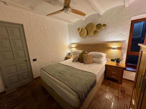 Un dormitorio con una cama y un ventilador de techo. en Canario Dunes Apartment, en Playa del Inglés