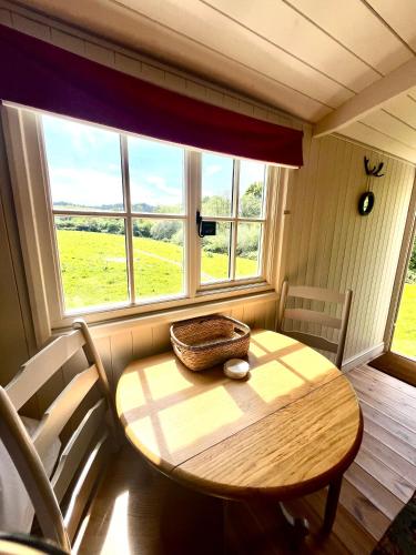 a table and chairs in a room with a window at Fallow Coombe Hut, South Downs National Park in Rake