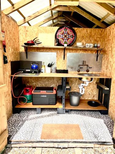 a kitchen with a counter and a sink in a room at Fallow Coombe Hut, South Downs National Park in Rake