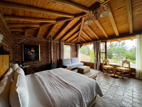 a bedroom with a large bed and a living room at Hacienda Jimenita Wildlife Reserve in Puembo