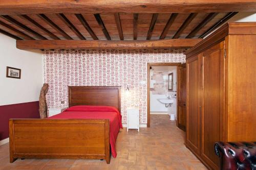 um quarto com uma cama vermelha e uma casa de banho em Le Mandrie Di San Paolo em Assisi