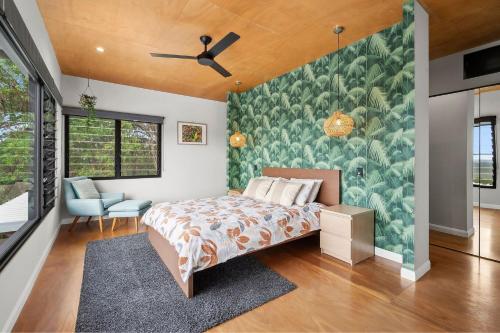 a bedroom with a bed and a green wall at Coolum Scenic Getaway - Mountain & Ocean views only 15 minutes from the beach in Yandina Creek