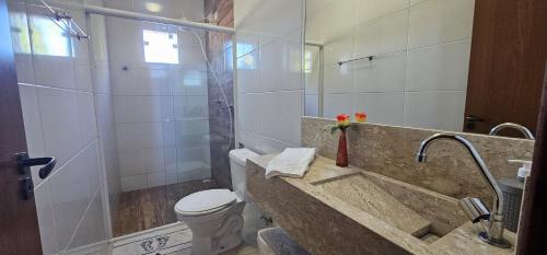 une salle de bain avec une douche, des toilettes et un lavabo dans l'établissement Casa Duplex Esperança - Ar e Garagem Privativa, à Bom Jesus da Lapa