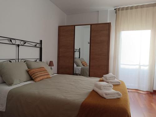 a bedroom with a large bed with towels on it at Apartamento Plaza de la Iglesia in Deltebre