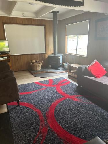a living room with a black and red rug at Huntinaddi Lodge in Halls Gap