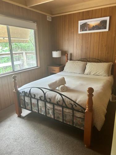 a bedroom with a large bed with a window at Huntinaddi Lodge in Halls Gap