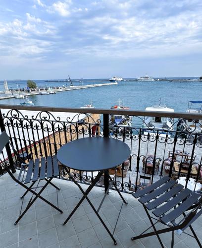a table and chairs on a balcony overlooking the water at The Stonehouse at the Harbor in Pythagoreio