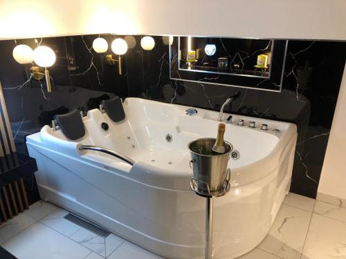 une baignoire dans une salle de bain aux murs noirs dans l'établissement Rent Room 4 Rolandi Apartments, à Pogradec