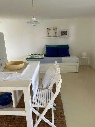 a white bedroom with a bed and a white chair at Apartmani Krk in Krk
