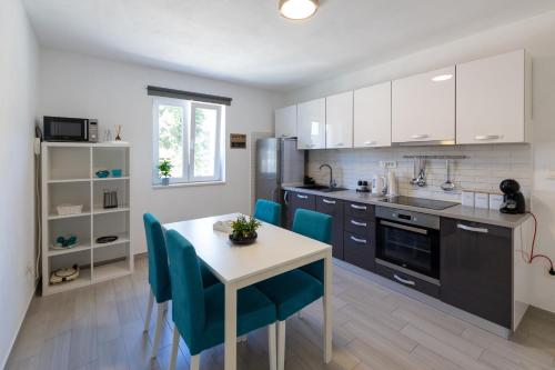 - une cuisine avec une table et des chaises bleues dans la chambre dans l'établissement Apartments with a parking space Hvar - 22023, à Hvar