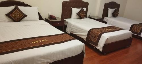 um quarto de hotel com três camas num quarto em Ngọc Lan Hotel em Ho Chi Minh