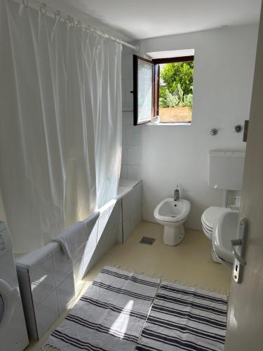 a bathroom with a sink and a toilet and a window at Apartmani Krk in Krk