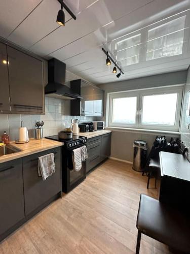 a kitchen with stainless steel appliances and wooden floors at Top Floor of the building, spectacular views! in Glasgow