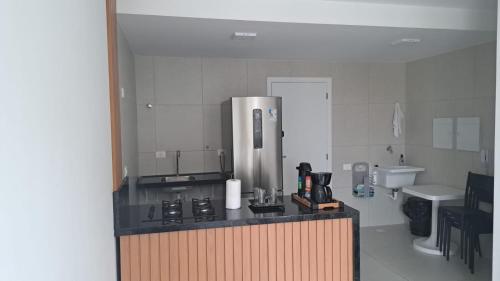 a kitchen with a counter with a stove and a sink at Edificio Nau no coração da Barra in Salvador