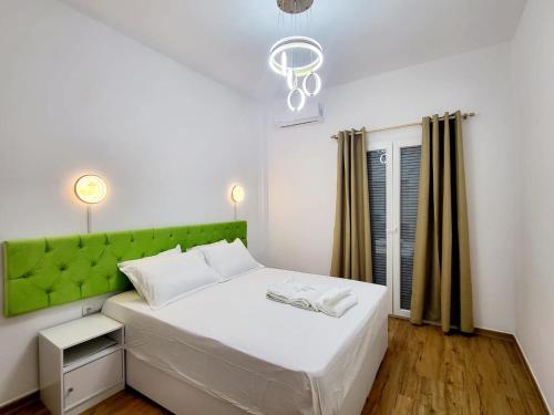a bedroom with a white bed with a green headboard at AHAMED GREEK SMPCO in Athens