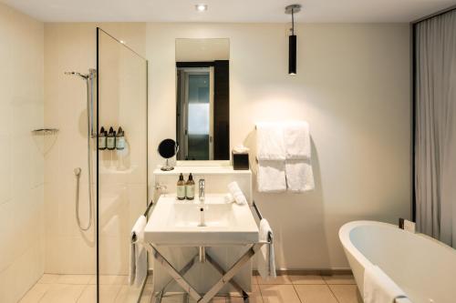 a bathroom with a sink and a tub and a bath tub at Queenstown Park Boutique Hotel in Queenstown