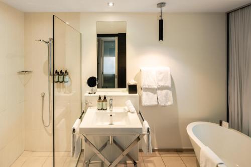 a bathroom with a sink and a tub and a bath tub at Queenstown Park Boutique Hotel in Queenstown