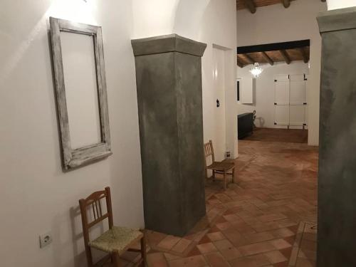 a room with two chairs and a mirror on a wall at Casa da Oliveira in Mértola