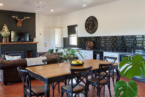 a kitchen and living room with a wooden table and chairs at The Caretakers Cottage in Belford