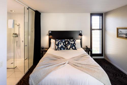 a bedroom with a large bed and a glass shower at Queenstown Park Boutique Hotel in Queenstown
