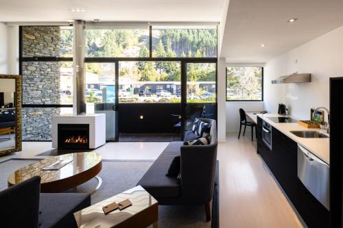 a kitchen and living room with a fireplace at Queenstown Park Boutique Hotel in Queenstown