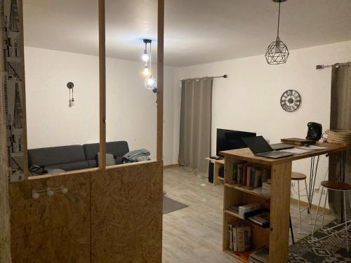 un salon avec un canapé et un bureau avec un ordinateur portable dans l'établissement Cœur de ville, à Jonzac